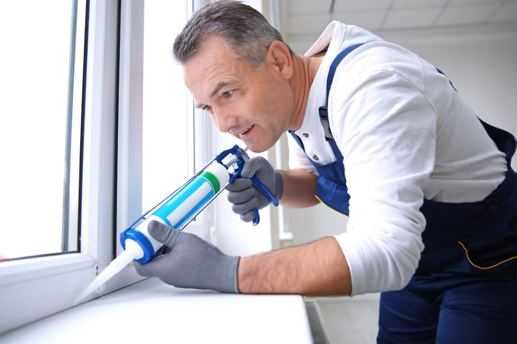 Construction worker installing window in house